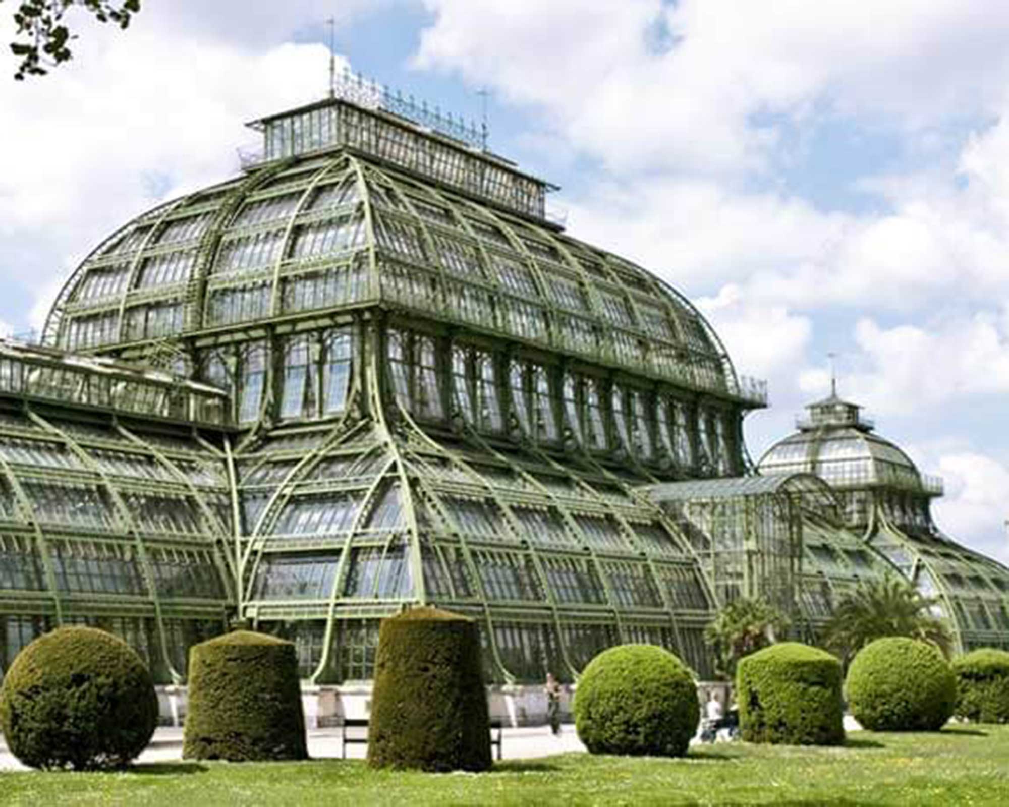 Bild als BKL Referenz für den Botanischer Garten Berlin: Historisches, großes Gewächshaus mit filigraner Glas-Stahl-Konstruktion, Renovierung mit Potain Kran MDT 178 von BKL Mietkrane, Millimeterarbeit bei begrenztem Platz.