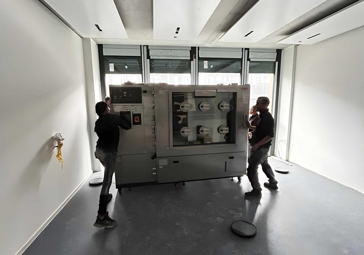 BKL Team montiert große Industriemaschine in modernem Raum, exemplarisch für Schwertransporte und Speziallogistik