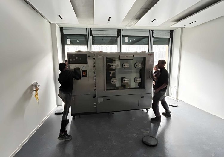 BKL Team montiert große Industriemaschine in modernem Raum, exemplarisch für Schwertransporte und Speziallogistik