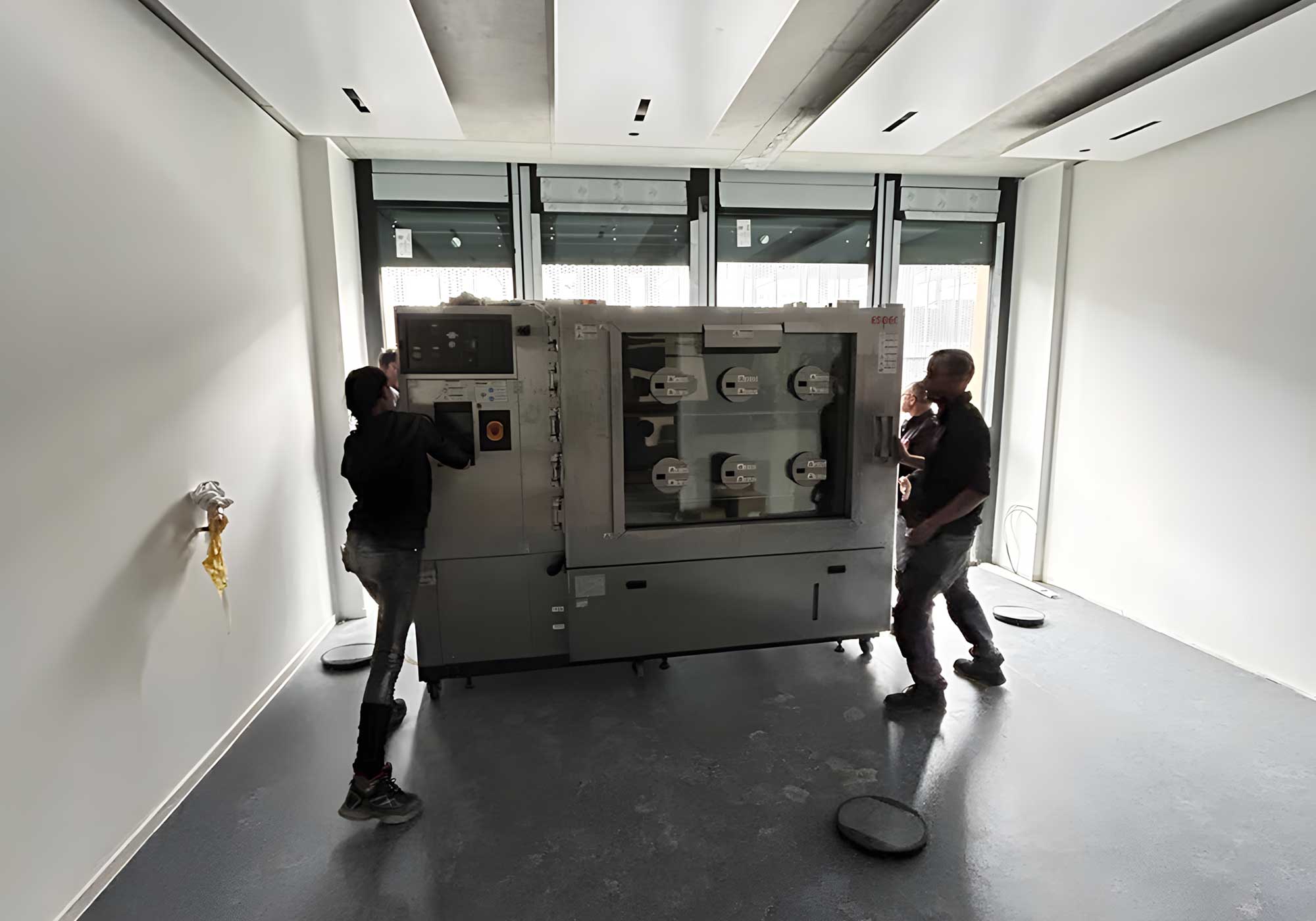BKL Team montiert große Industriemaschine in modernem Raum, exemplarisch für Schwertransporte und Speziallogistik