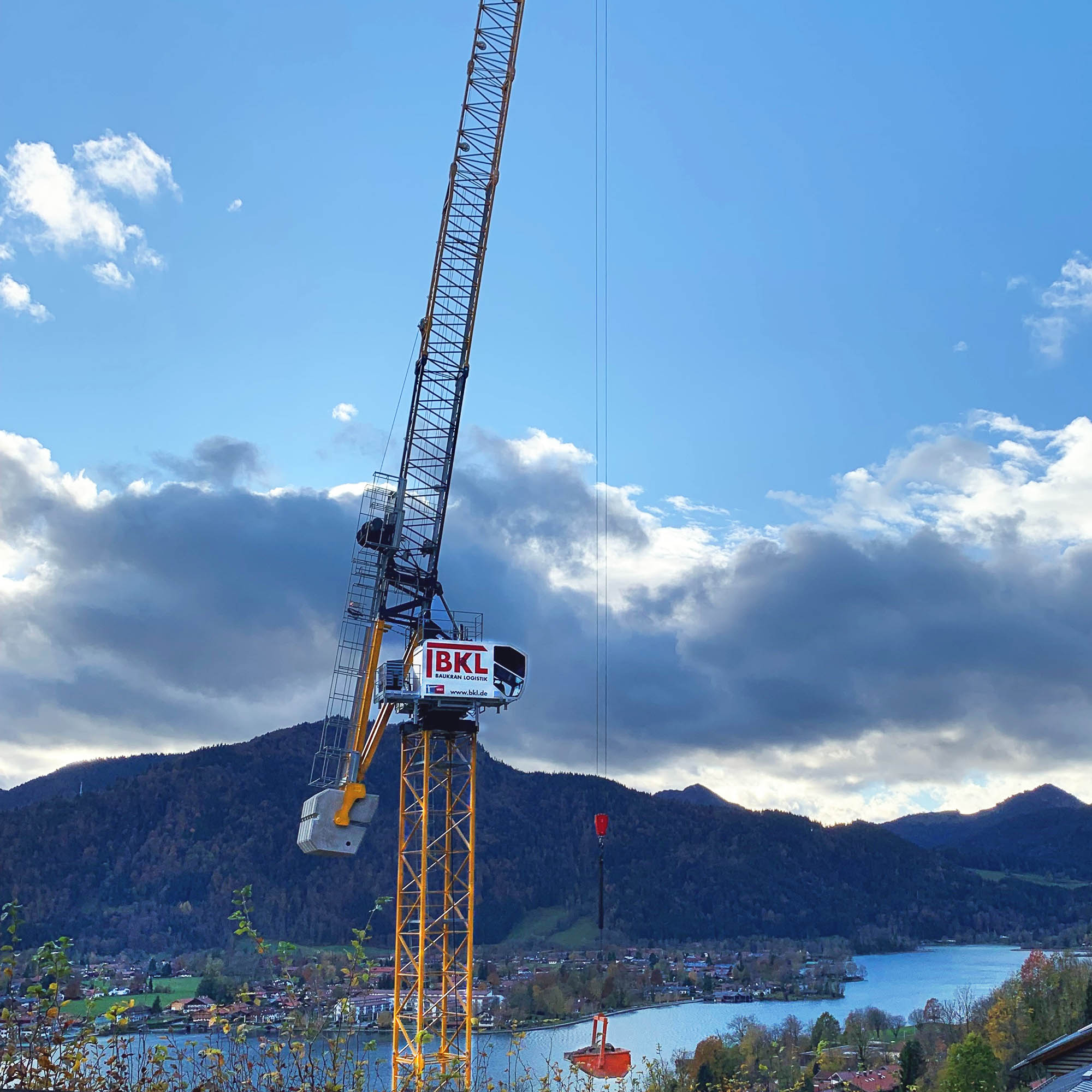 BKL System Sáez Wippkran SLH 205 vor einer Bergkulisse und einem See bei Hebearbeiten