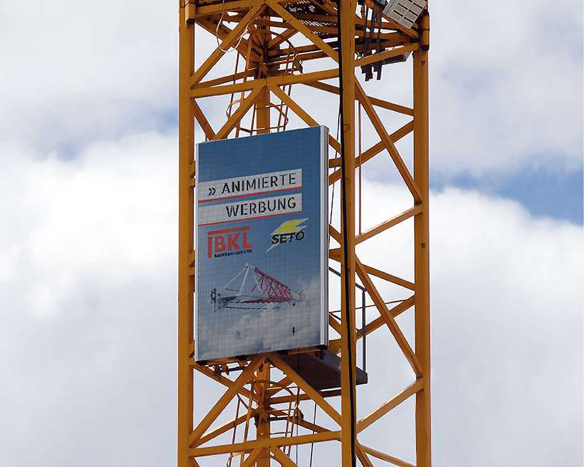 Zeigt Werbetafel an einem Kran, das bei BKL als Turmdrehkran-Zubehör erhältlich ist.