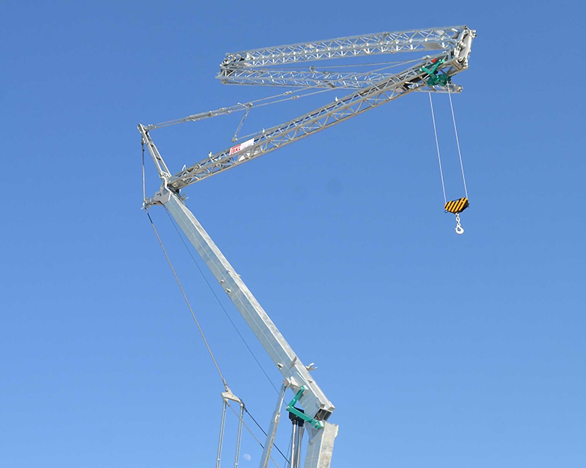 Cattaneo Schnellmontagekran vor blauem Himmel mit platzsparender Ausführung für enge Baustellen.