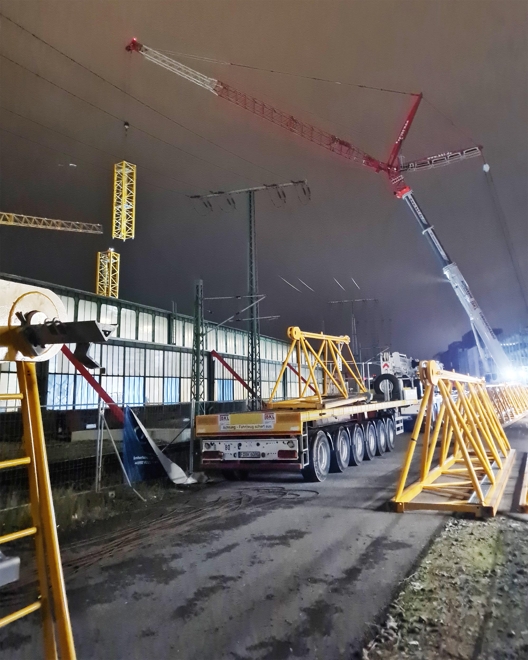 BKL montiert die Teile des Baukrans TLS 80 20 am Boden vor, der Autokran hebt die Kranteile ein