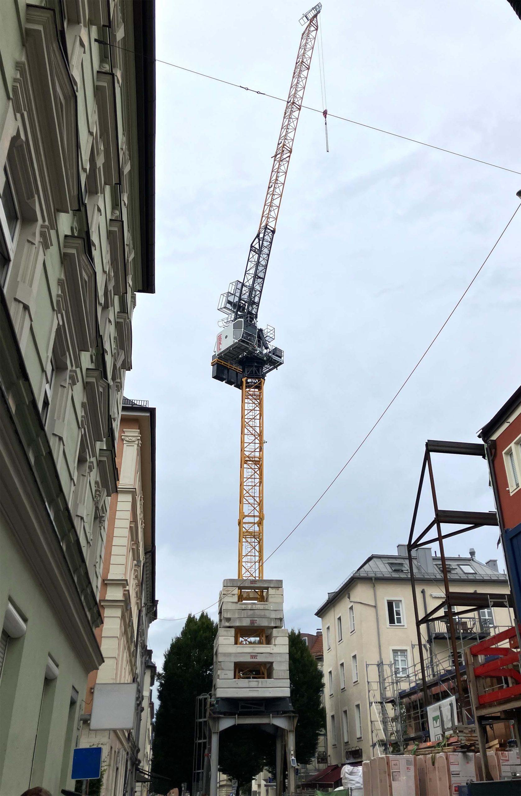 Ein Wippkran SLH 70.4 aus dem BKL System Cattaneo auf Portal in einer schmalen Straße zwischen Häusern in der Innenstadt